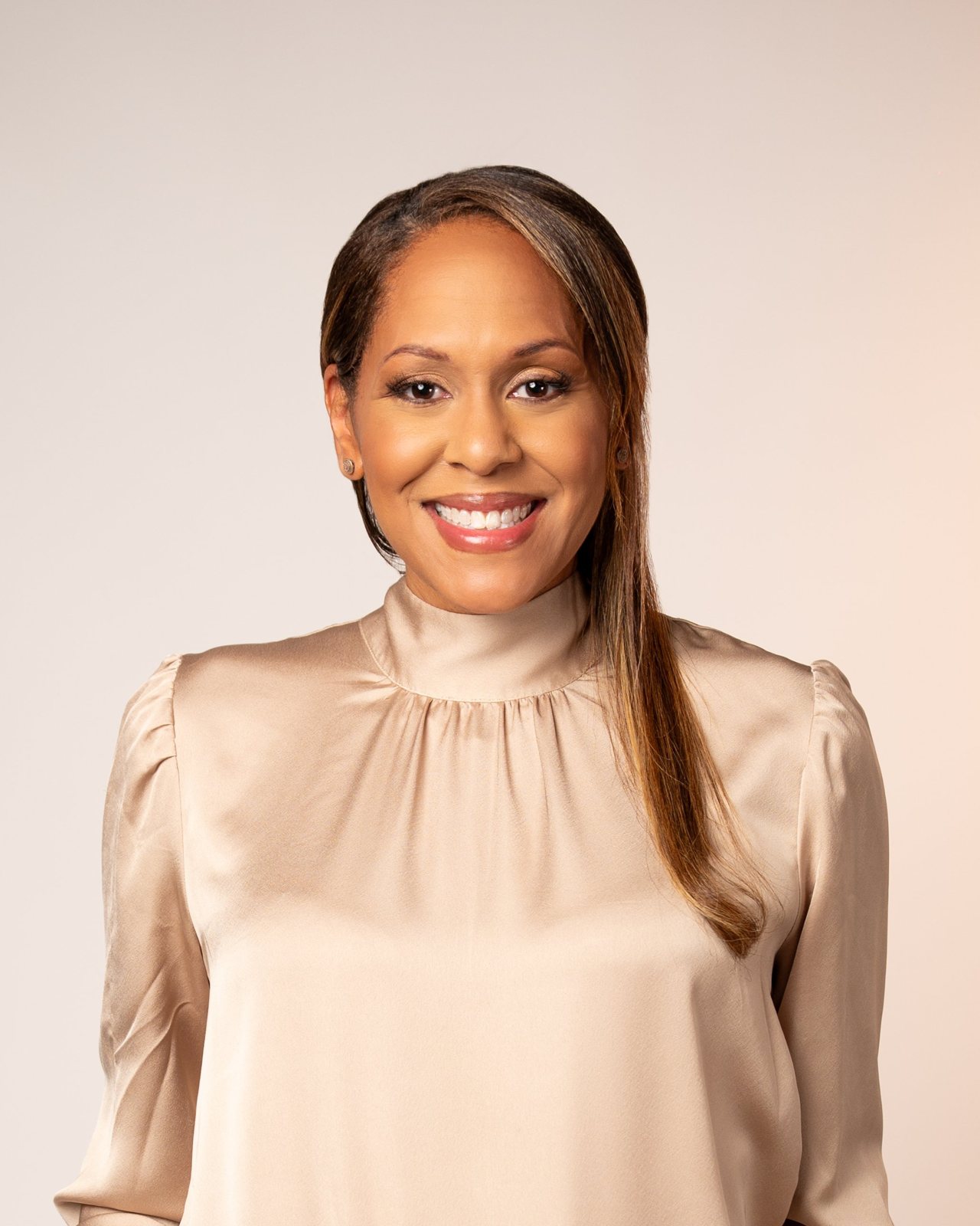 Janine Lequay smiling in a champagne satin blouse
